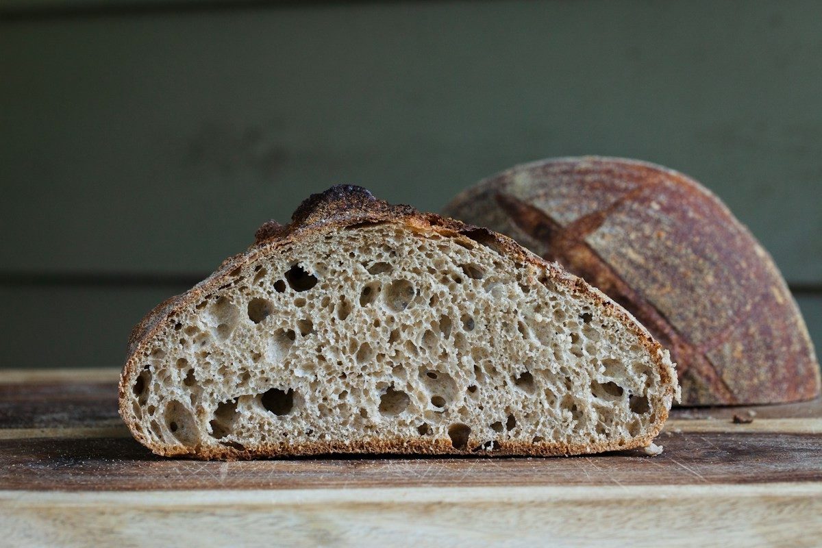 Angeschnittenes Brot mit dunkler Kruste auf hellem Grund