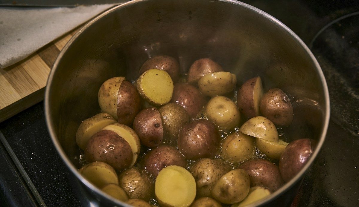 Kleine Kartoffeln mit roter und heller Schale kochen in einem Topf auf dem Herd
